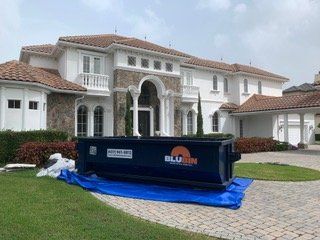 BluBin dumpster on a tarp in front of a home in Windermere, FL